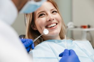Image of pretty woman sitting in dental chair while professional