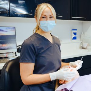 Practice manager about to do some work on a dental patient in the chair