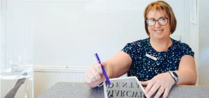 Receptionist using tablet to fill out dental plans form